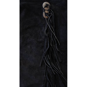 May include: Black suede skirt with a long fringe detail and three silver-toned buttons.