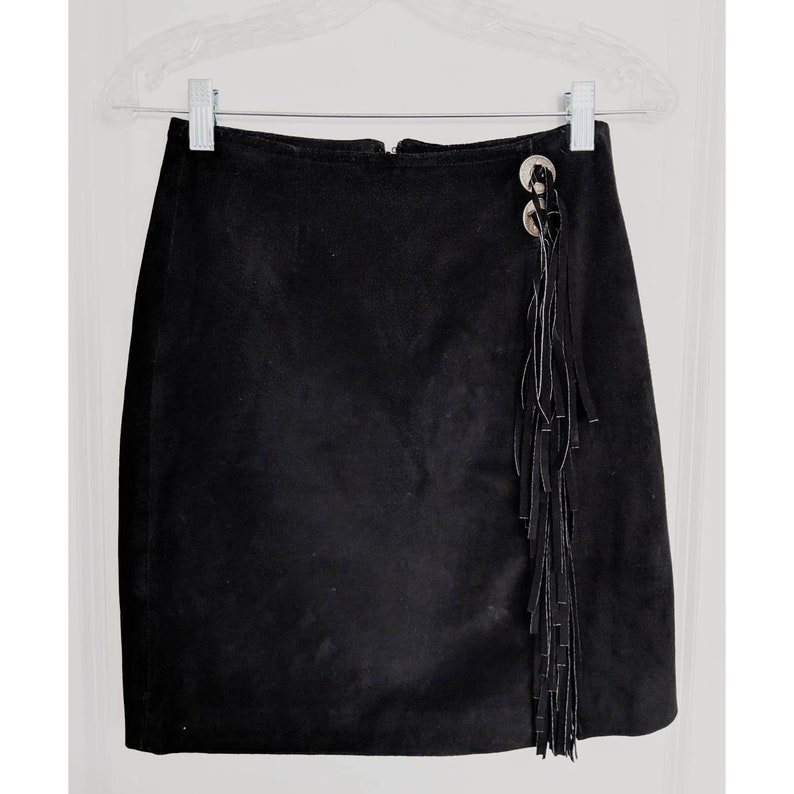 May include: A black suede mini skirt with a fringe detail and silver button accents.