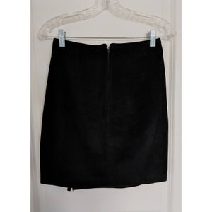 May include: A black suede mini skirt with a zipper closure in the back.