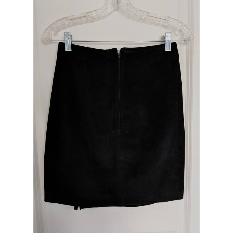 May include: A black suede mini skirt with a zipper closure in the back.