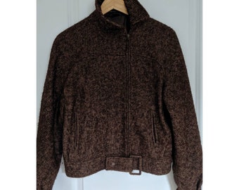 May include: A brown tweed jacket with a zipper closure and a belt at the waist.