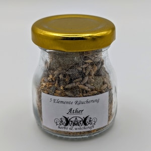 Op de afbeelding: Een klein glazen potje met een gouden deksel gevuld met gedroogde kruiden en een wit etiket met de tekst "5 Elemente Räucherung Äther herbs & witchcraft".