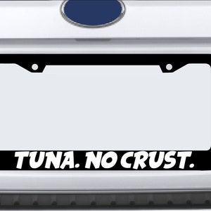 May include: Black license plate frame with white text that reads "TUNA. NO CRUST."