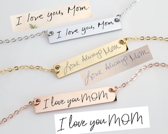 May include: A collection of personalized bar necklaces in silver, gold, and rose gold. Each necklace features a handwritten message: "I love you, Mom" or "Love Always Mom". The necklaces are displayed with matching handwritten notes.