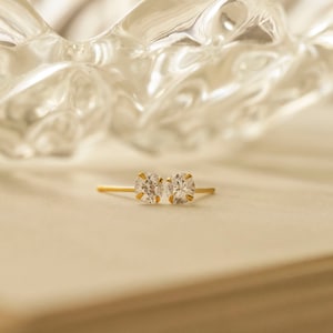 May include: A pair of gold stud earrings with clear round cubic zirconia stones.