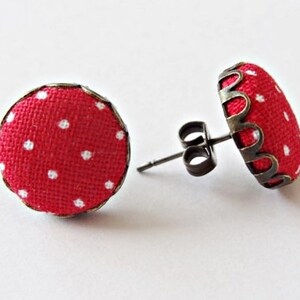 May include: A pair of red and white polka dot fabric earrings with silver-toned metal settings and posts.