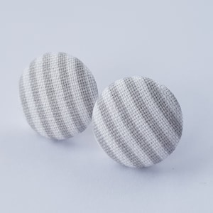 Könnte beinhalten: Ein Paar Ohrringe aus Stoff mit grauen und weißen Streifen.