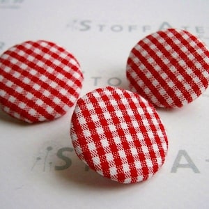 Könnte beinhalten: Drei rote und weiße Gingham-Stoffknöpfe.