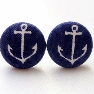 May include: A pair of navy blue fabric button earrings with white anchor designs.