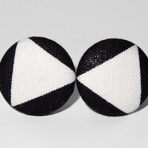 Könnte beinhalten: Ein Paar schwarze und weiße Stoffknopf-Ohrringe mit einem dreieckigen Design.