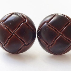 May include: A pair of brown leather-look earrings with a quilted design.