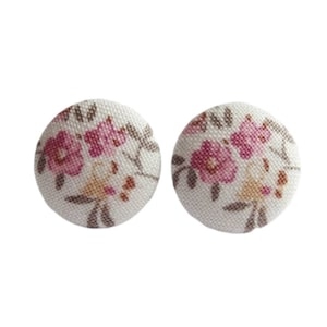 Może przedstawiać: Para białych kolczyków z tkaniny z różowym wzorem kwiatowym.