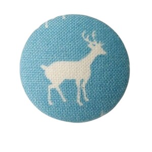 Könnte beinhalten: Ein hellblauer Stoffknopf mit einer weißen Hirsch-Silhouette.