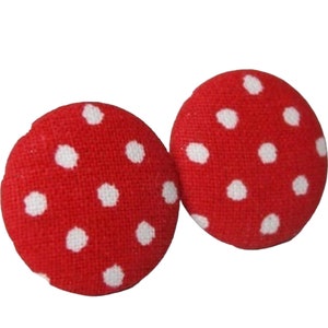 May include: A pair of red fabric earrings with white polka dots.