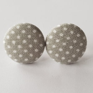 May include: A pair of grey fabric earrings with white polka dots.