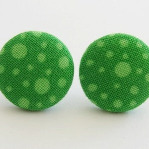 May include: A pair of green fabric earrings with a white polka dot pattern.