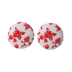 Può includere: Un paio di orecchini a bottone in tessuto bianco con un motivo floreale rosso.