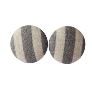 May include: A pair of round, gray and white striped fabric earrings.