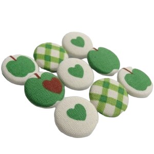 Könnte beinhalten: Sortiment aus acht grünen und weißen Stoffknöpfen mit Apfel- und Herzmotiven.