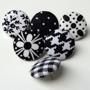 Op de afbeelding: Zes ronde zwarte en witte stoffen knopen met verschillende patronen. De knopen zijn ongeveer 2,5 cm in diameter.