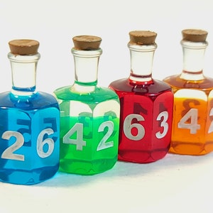 May include: Four small glass bottles with cork stoppers filled with different coloured liquids. Each bottle has a different number on each side: 2, 6, 4, 2, 1, 6, 3, 4, 2.