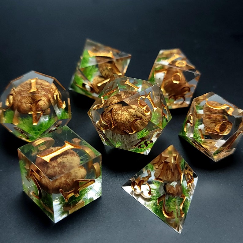Handmade epoxy resin 7 dice set for dnd and tabletop rpg games with boletus mushrooms inside.
Mushrooms are 3D printed and hand painted. All edges are as sharp and straight as possible, and the planes are manually drawn to a mirror shine. The numbers are painted in light brass/golden color.
You can choose 7dice set or only d20 to order. We also offer to choose a gift box made of natural oak with laser engraving according to your wish.