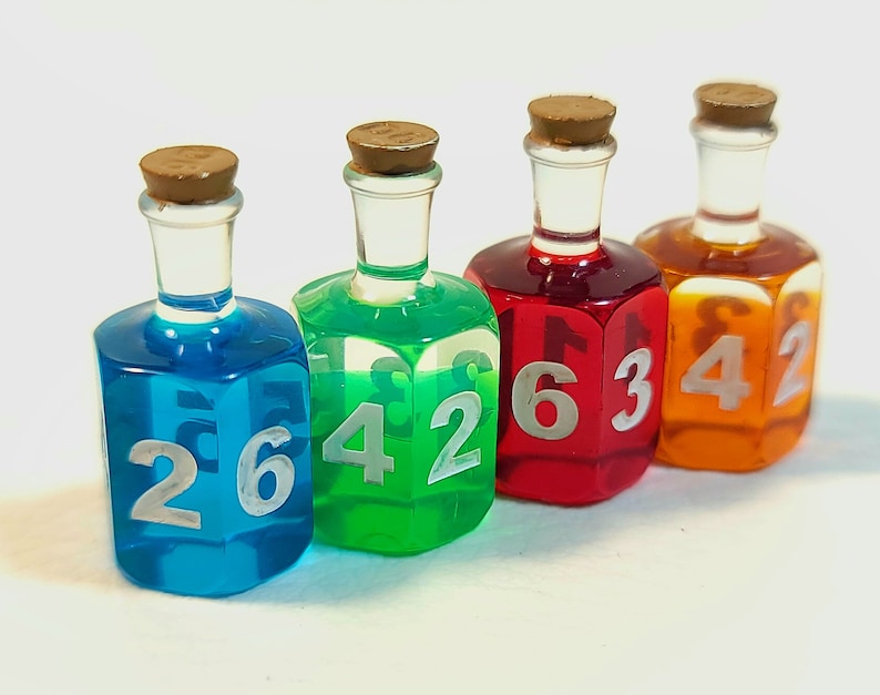 May include: Four small glass bottles with cork stoppers filled with coloured liquid and numbered dice faces. The bottles are blue, green, red, and orange.