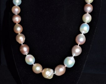 May include: A pearl necklace with iridescent pearls in shades of pink, green, and white. The pearls are strung on a thin silver chain.