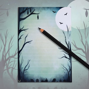 Op de afbeelding: Een blauwe en witte Halloween-thema notitieboek met een volle maan, vleermuizen en bomen. Het notitieboek heeft gestreept papier en is perfect om je griezelige ideeën op te schrijven.