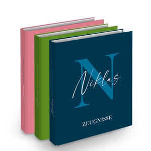 Könnte beinhalten: Drei Hardcover-Journale in Blau, Grün und Rosa mit dem Wort "ZEUGNISSE" und dem Namen "Niklas" in weißer Schrift auf der Vorderseite des blauen Journals.