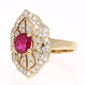 May include: A gold ring featuring a large red ruby gemstone surrounded by smaller diamonds in a delicate floral design.