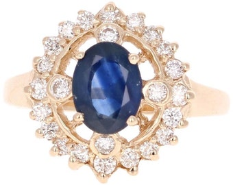 May include: A gold ring with a large blue sapphire surrounded by a halo of smaller diamonds.