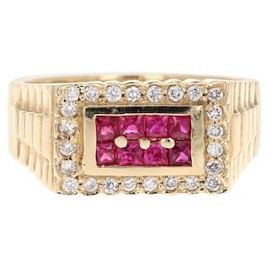 May include: A gold ring with a rectangular ruby center surrounded by a halo of diamonds. The band is textured and has a gold finish.