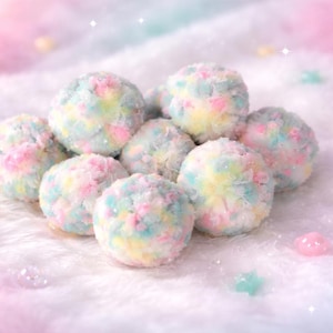 Puede incluir: Un grupo de esferas esponjosas de colores pastel, que parecen algodón de azúcar, están dispuestas sobre una superficie blanca y suave. Las esferas son una mezcla de azul claro, rosa y amarillo. Pequeñas cuentas iridiscentes en forma de estrella y redondas están dispersas.