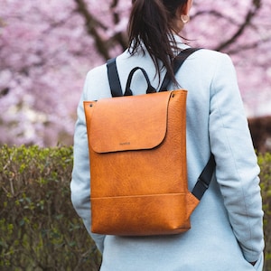 Frau mit handgefertigtem Rucksack mit der Farbe Cognac