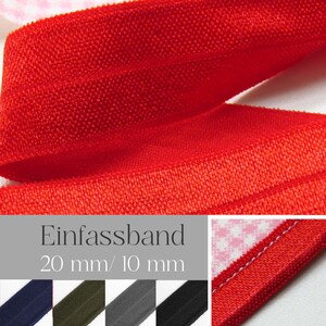 Könnte beinhalten: Nahaufnahme eines leuchtend roten Gummibands. Der Stoff hat ein strukturiertes Aussehen. Das Bild zeigt auch den Text "Einfassband 20 mm/ 10 mm" und eine Farbpalette anderer Gummibandfarben.