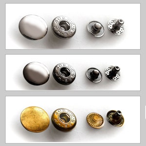 Könnte beinhalten: Drei Sätze Metall-Druckknöpfe, jeder Satz enthält eine Kappe, eine Buchse und einen Stift. Der erste Satz ist silber, der zweite ist schwarz und der dritte ist gold.