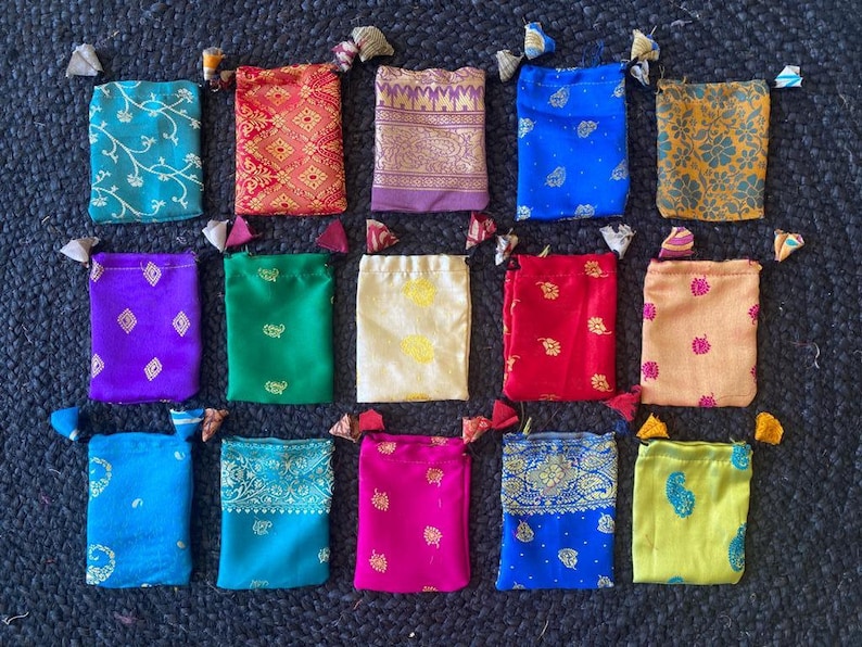 May include: Assortment of 15 small drawstring bags made from colorful patterned fabric. The bags are approximately 4 inches wide and 5 inches tall.