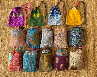 May include: A collection of 15 colorful drawstring bags made from recycled saris. The bags are all different sizes and patterns, and they are perfect for carrying small items.