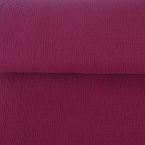 Könnte beinhalten: Eine Rolle tief burgunderfarbener Stoff mit einer strukturierten, geknitterten Oberfläche.