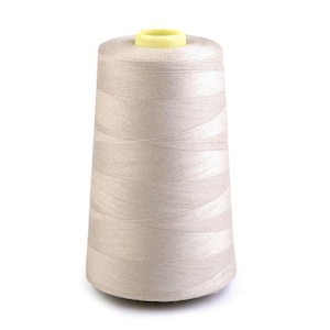 Könnte beinhalten: Eine Spule beigefarbenen Garns mit einem gelben Plastikdeckel.