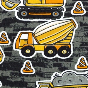 Puede incluir: Una tela negra y gris con un patr&oacute;n repetitivo de veh&iacute;culos de construcci&oacute;n amarillos y conos de tr&aacute;fico naranjas. Los veh&iacute;culos incluyen una mezcladora de cemento, una excavadora y un cami&oacute;n volquete.