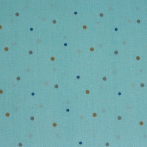 Könnte beinhalten: Nahaufnahme eines hellblauen Stoffes mit einem sich wiederholenden Muster aus kleinen, gleichmäßig verteilten Polka-Punkten. Die Punkte sind in Blau-, Braun- und Grautönen gehalten und erzeugen ein subtiles, strukturiertes Design. Der Stoff hat ein leicht gewebtes Aussehen.
