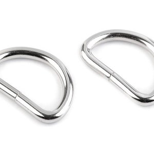 Könnte beinhalten: Zwei silberne D-Ringe aus Metall, auch bekannt als D-Ringe oder D-förmige Ringe, werden vor einem weißen Hintergrund gezeigt.