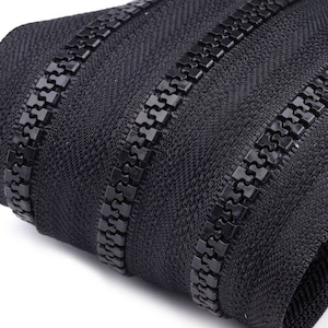 Könnte beinhalten: Schwarzes Reißverschlussband mit drei Reihen schwarzer Zähne. Das Reißverschlussband ist aus einem gewebten Stoff gefertigt und eignet sich für Nähprojekte.