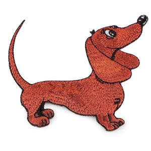 Könnte beinhalten: Gestickter Aufnäher eines Dackelhundes in Rotbraun. Der Hund ist in einer spielerischen Pose dargestellt, blickt nach oben mit einer schwarzen Nase und einem gebogenen Schwanz. Für Kleidung oder Accessoires.