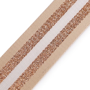 Op de afbeelding: Beige lint met twee witte strepen die een gouden glitterafwerking hebben.