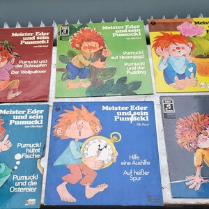 Pode incluir: Uma coleção de oito discos de vinil vintage com o personagem de livro infantil alemão Pumuckl. Os discos são de várias cores, incluindo amarelo, azul, verde e vermelho. Cada disco apresenta uma ilustração de Pumuckl e Meister Eder, juntamente com o título da história.