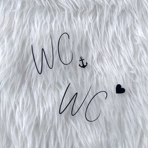 May include: White fluffy background with the text "WC" written twice in black cursive. A small black anchor symbol is between the first two letters of the first "WC" and a small black heart is to the right of the second "WC".