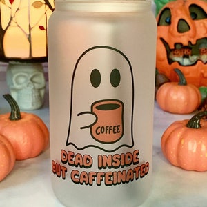 Może przedstawiać: Frosted szklanka z bambusową pokrywką i słomką. Szklanka przedstawia kreskówkowego ducha trzymającego kubek do kawy z napisem "Coffee". Pod duchem znajduje się napis "Dead Inside But Caffeinated".